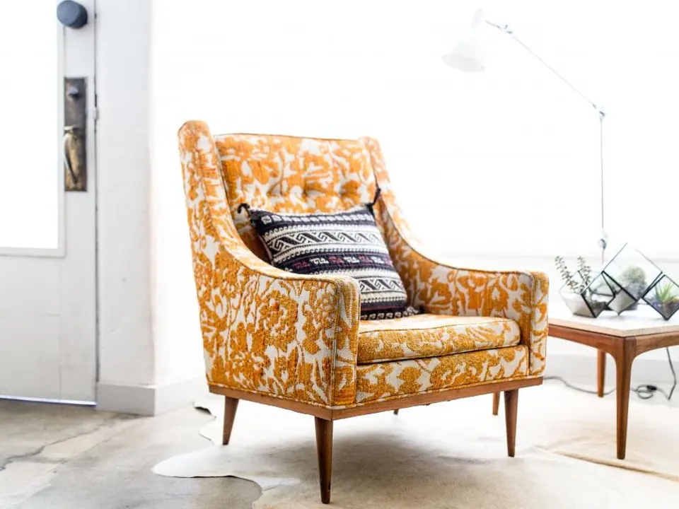 Styled interior with a patterned orange armchair and side table