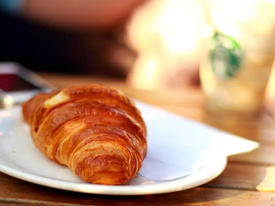 Golden croissant on a white plate