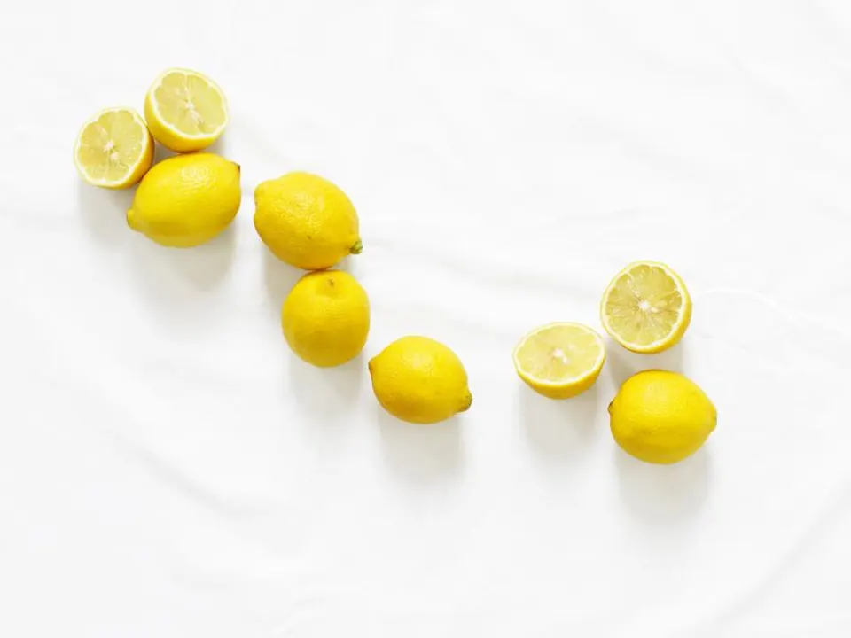 Fresh lemons scattered on a white surface