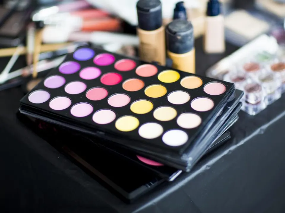 Colorful eyeshadow palette and makeup on a dark table